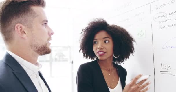 Whats your view on the matter. 4k video footage of a group of businesspeople working on a whiteboard in their workplace. — Wideo stockowe