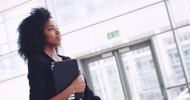 I got this in the bag. 4k video footage of a young confident businesswoman walking with a digital tablet and showing a friendly hand gesture to the camera at work. — Stockvideo