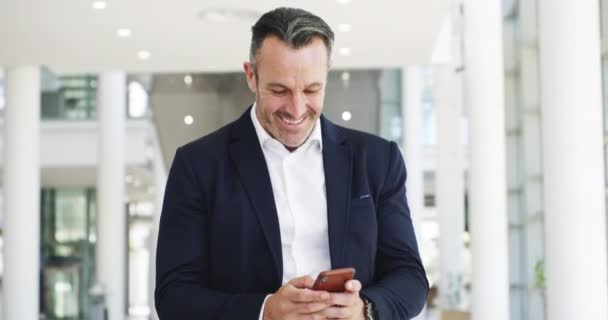 I received a good luck message from the wife. 4k video footage of a focussed young businessman texting on his phone while walking around at work during the day. — Stockvideo