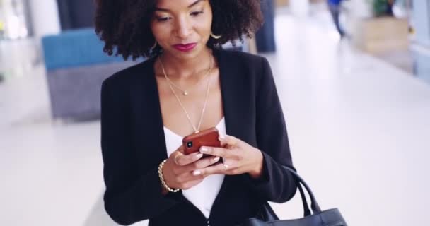 This conversation can go on all day. 4k video footage of a focussed young businesswoman texting on her phone while walking around at work during the day. — Vídeo de Stock