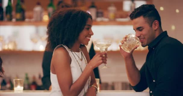 As bebidas estão fluindo e assim é a atração. Filmagem em vídeo 4k de jovens e mulheres brindando com suas bebidas em um bar. — Vídeo de Stock