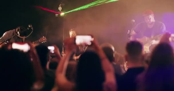 One night, lots of awesome memories. 4k video footage of a crowd of people photographing a live musical performance with their smartphones. — ストック動画