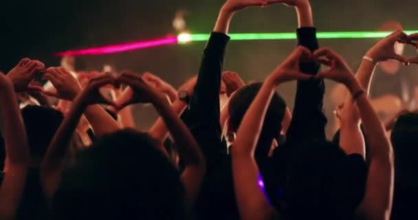 É hora de se apaixonar pela vida. Filmagem em vídeo 4k de uma multidão de pessoas fazendo gestos em forma de coração durante uma performance musical ao vivo. — Vídeo de Stock