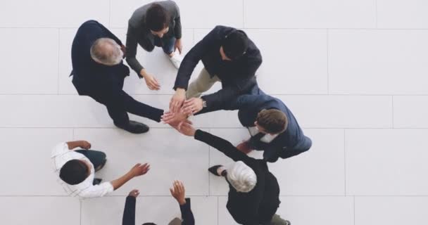Motivation is what gets us ahead. 4k footage of a group of businesspeople joining their hands together in a huddle. — Vídeos de Stock