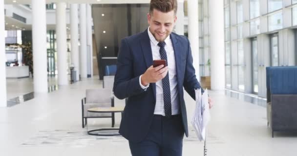 Profit keeps a business engine running. 4k video footage of a young businessman throwing his paperwork in the air after receiving good news on his smartphone. — Video