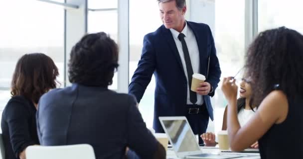 The boss is here to show them how business is done. 4k video footage of a businessman shaking hands with colleagues before giving a presentation in an office. — стоковое видео