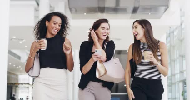 Οι καλύτεροι φίλοι στη δουλειά. 4k βίντεο με νεαρές επιχειρηματίες να κουβεντιάζουν και να χρησιμοποιούν smartphone ενώ περπατούν σε ένα γραφείο σε διάλειμμα για καφέ. — Αρχείο Βίντεο