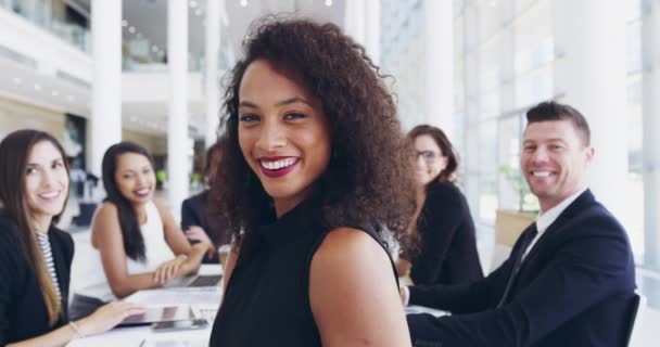 Были все выдающиеся в деловой игре. 4k видеозапись молодой деловой женщины, улыбающейся в офисе во время встречи со своими коллегами на заднем плане. — стоковое видео
