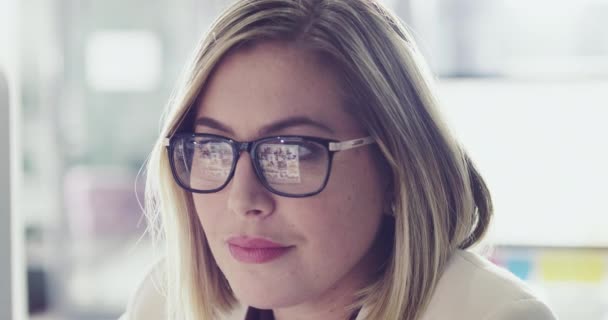 Computer literacy is an integral part of her job. 4k footage of a happy businesswoman working behind her computer screen in the office. — 비디오