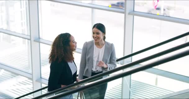 Der Beginn des Tages. 4k-Videomaterial von zwei attraktiven jungen Geschäftsfrauen, die bei der Arbeit die Rolltreppe hinaufsteigen. — Stockvideo