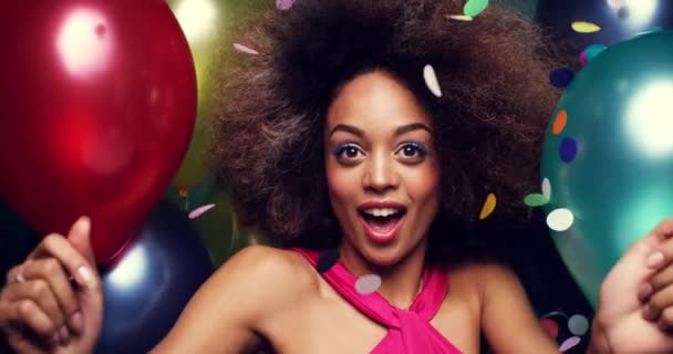 Cheerful hispanic woman celebrating and dancing with balloons. Happy young woman having fun dancing with colourful balloons and confetti shaking her afro. Carefree young woman dancing with balloons — Stockvideo