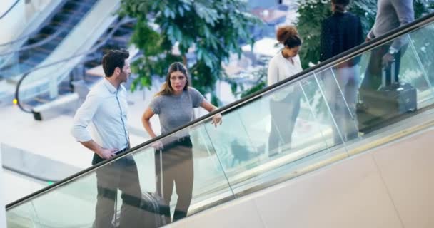 Getting to the top, together. 4k video footage of two businesspeople going up the elevator in an airport. — Stock video