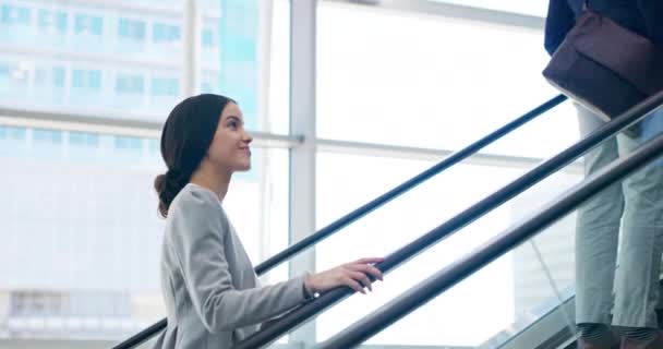 Va camino a la cima. Imágenes de video de 4k de una atractiva joven empresaria subiendo por la escalera mecánica en el trabajo. — Vídeos de Stock