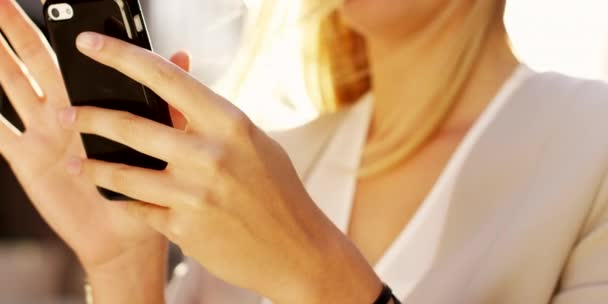 Businesswoman using her smartphone while walking to work. Closeup on the hands of a businesswoman sending a text message on her cellphone. A businesswoman using an online app on her wireless phone — Stock video