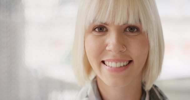 Portrait of a happy young businesswoman smiling in her office. Headshot of a face of a blonde businesswoman smiling in her office. A young caucasian businesswoman smiling — Vídeo de stock