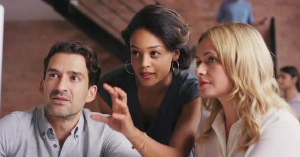 A group of businesspeople using a computer in a modern office. Powerful young businesswoman collaborating with colleagues working on a computer. Serious businesspeople talking in a meeting — Video Stock