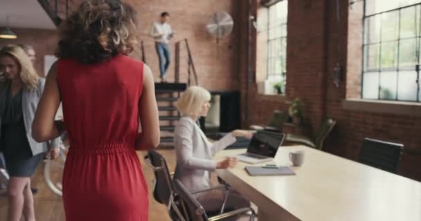 A businesswoman helping a group of diverse team members in her office. Happy businesswoman walking through her office talking to staff. Young Hispanic boss collaborating with colleagues in the office — Vídeo de stock