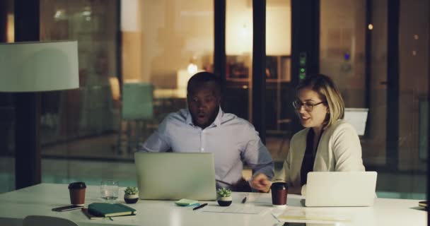 Theyre getting closer to crushing their deadline. 4k footage of two focussed business colleagues working on laptops in the office after hours. — Stockvideo