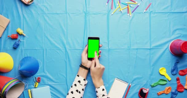 4k video footage of an unrecognisable event planner sitting alone in the studio and using her cellphone — Vídeos de Stock