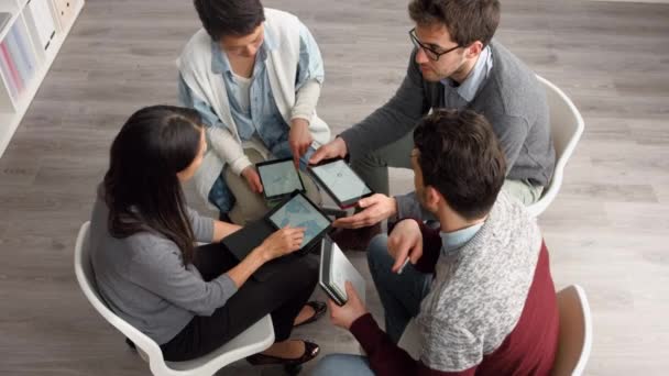 Beyin fırtınası sırasında dijital tablet kullanan bir grup mutlu genç iş adamı. Bir grup iş arkadaşı planlama seansları sırasında konuşmak ve işbirliği yapmak için teknoloji tabletleri kullanıyor.. — Stok video