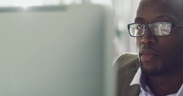 No distractions when hes in work mode. 4k footage of a focussed young businessman working behind his computer screen in the office. — Stockvideo