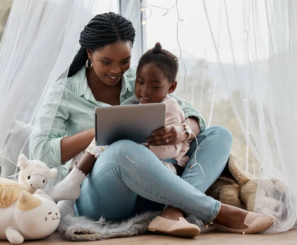 Laten we eerst onze buikspieren doen. Shot van een vrouw met behulp van een digitale tablet tijdens het zitten met haar dochter. — Stockfoto