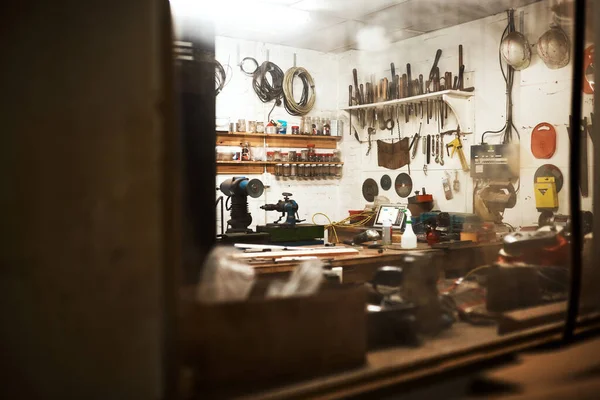 This is my workshop. Shot of a workshop filled with different types of tools inside someones home at night. — Stock Photo, Image