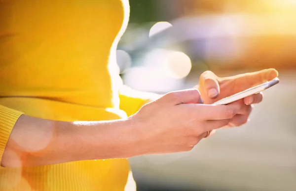 Transmita sua mensagem com tecnologia inteligente. Tiro cortado de uma jovem mulher irreconhecível usando um smartphone fora. — Fotografia de Stock