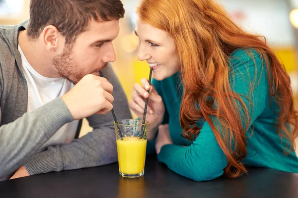 쥬스 로맨스. 어느 카페에서 데이트하는 행복 한 젊은 부부가 주스를 마시고 있는 장면 이 포착되었다. — 스톡 사진
