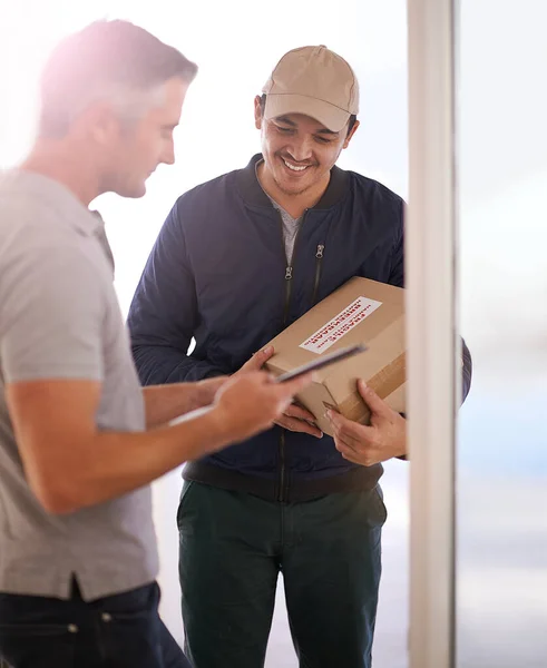 Firma abajo. Fotografía de un mensajero haciendo una entrega a un cliente sonriente. —  Fotos de Stock