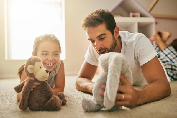 Ele tem um nome? Tiro de um jovem bonito e sua filha brincando com brinquedos de pelúcia no chão do quarto. — Fotografia de Stock