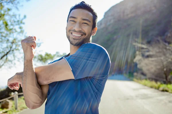 Ik kom in een goede opwarming. Schot van een knappe jongeman die alleen staat en zich uitstrekt tijdens zijn outdoor training. — Stockfoto