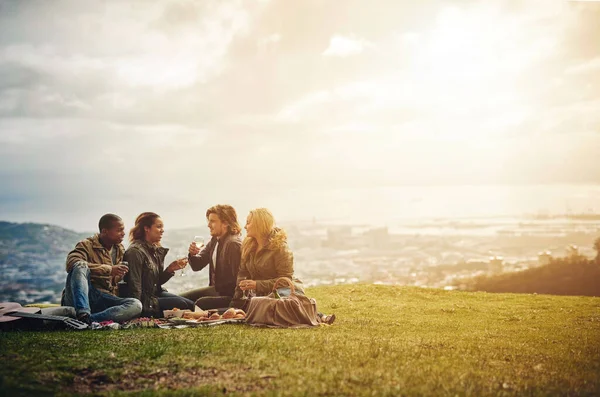 Ver van het lawaai van de stad. Foto van een groep jonge vrienden die plezier hebben bij een picknick. — Stockfoto