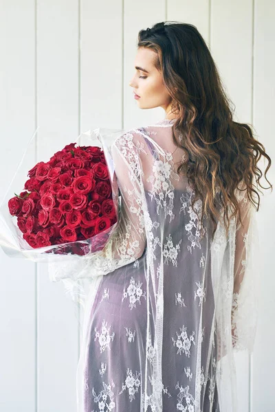 A virágok kiszedik belőled a hölgyet. Visszapillantás egy gyönyörű fiatal nőről, aki csukott szemmel áll, miközben egy csokor rózsát tart odakint.. — Stock Fotó