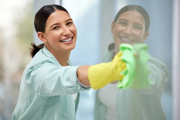 Doe je best. Foto van een mooie jonge vrouw die haar ramen schoonmaakt. — Stockfoto