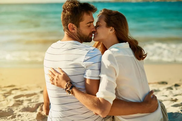 夏のロマンスはこれより良くならない。ビーチで夏の日にキスをする若いカップルのショット. — ストック写真