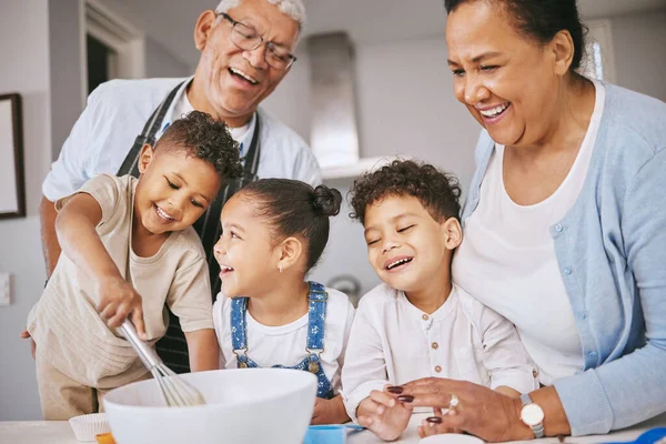 Are those little balls or lumps. Shot of a mature couple baking with their grandkids at home. — Stock Photo, Image