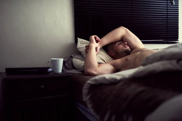 Acordar no seu próprio ritmo. Tiro de um jovem sem camisa dormindo em sua cama. — Fotografia de Stock