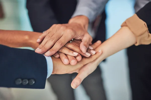 Get together and lets make this work. Closeup of a group of unrecognizable businesspeople forming a huddle with their hands while standing in the office during the day. — Stock Photo, Image