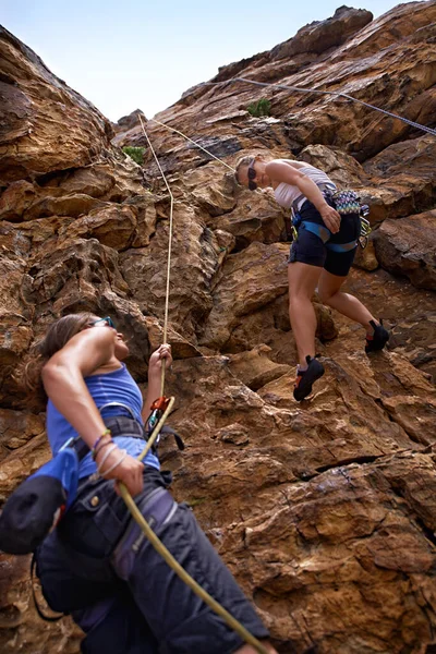 Όλα έχουν να κάνουν με την εμπιστοσύνη - το ρελέ. Δύο γυναίκες ορειβάτες σκαρφαλώνουν σε ένα πρόσωπο βράχου. — Φωτογραφία Αρχείου