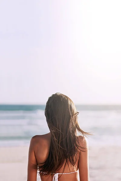 Plaża zawsze będzie idealnym miejscem na lato. Zdjęcie z tyłu nierozpoznawalnej młodej kobiety na plaży. — Zdjęcie stockowe