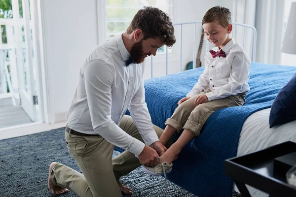 Dostává svůj styl od táty. Vystřižené záběr na mladého pohledného otce pomáhá jeho rozkošný syn dal na boty doma. — Stock fotografie
