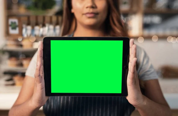 Sprzedaj się, żeby oddzielić się od konkurencji. Zdjęcie z bliska nierozpoznawalnej kobiety trzymającej w kawiarni cyfrowy tablet z zielonym ekranem. — Zdjęcie stockowe