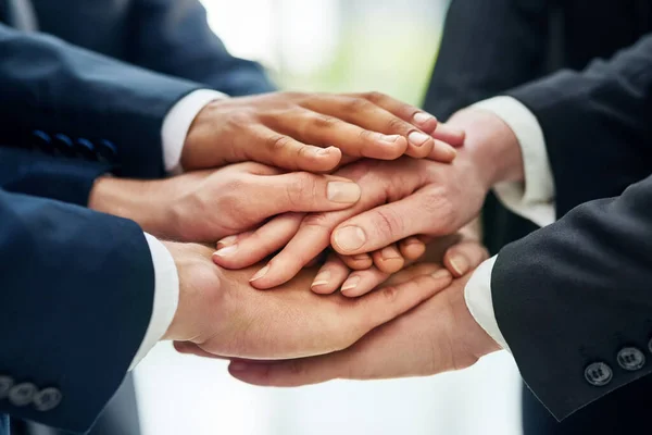 Success and solidarity. Closeup shot of a group of businesspeople standing in a huddle with their hands stacked together. — Stock Photo, Image