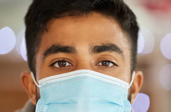 Esta máscara foi feita para minha protecção e para a tua. Retrato de um jovem vestindo uma máscara cirúrgica dentro de casa. — Fotografia de Stock