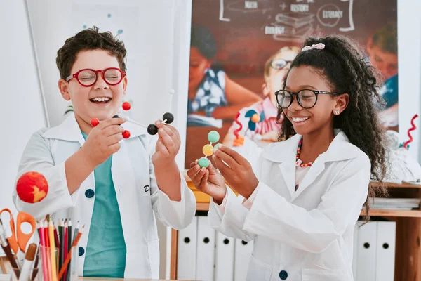 科学が関与している退屈な瞬間は決してありません。学校の理科の授業で分子について学ぶ2人の愛らしい若い子供のショット. — ストック写真