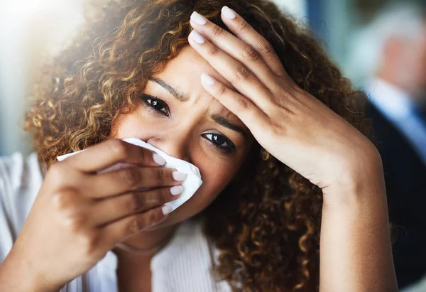 Ora mi fa male anche la testa. Primo piano di una donna d'affari frustrata che usa un fazzoletto per pulirsi il naso mentre è seduta in ufficio. — Foto Stock