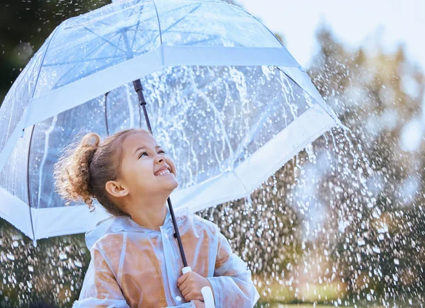Ця парасолька мене захистить. Знімок маленької дівчинки, грайливо стоїть під дощем, тримаючи її парасольку . — стокове фото