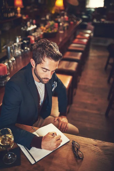 Todo comienza con una trama. Foto de ángulo alto de un joven sentado con su diario en un bar. —  Fotos de Stock