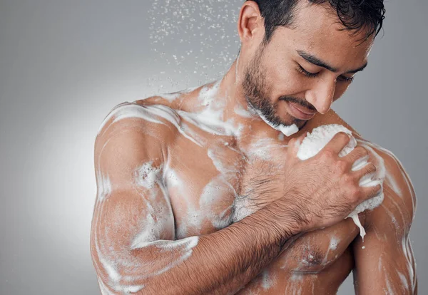 Acércalo. Fotografía de un joven tomando una ducha sobre un fondo gris. —  Fotos de Stock